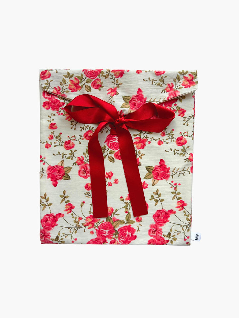 Red floral patterned fabric envelope pouch tied with a red ribbon on a white background.