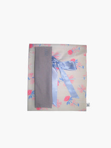 grey stretch headband, sat on top of a floral patterned ribbon tied fabric git pouch, set against a white background