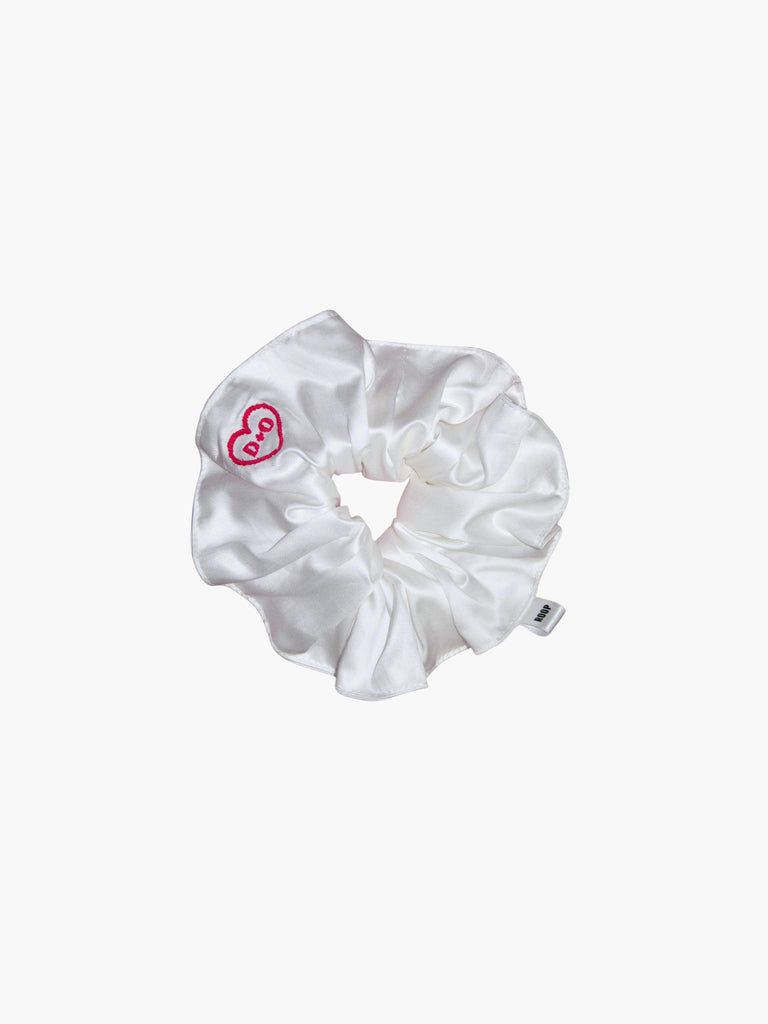 Ivory bamboo silk satin scrunchie embroidered with a red heart with the initials D+O inside, set on a white background