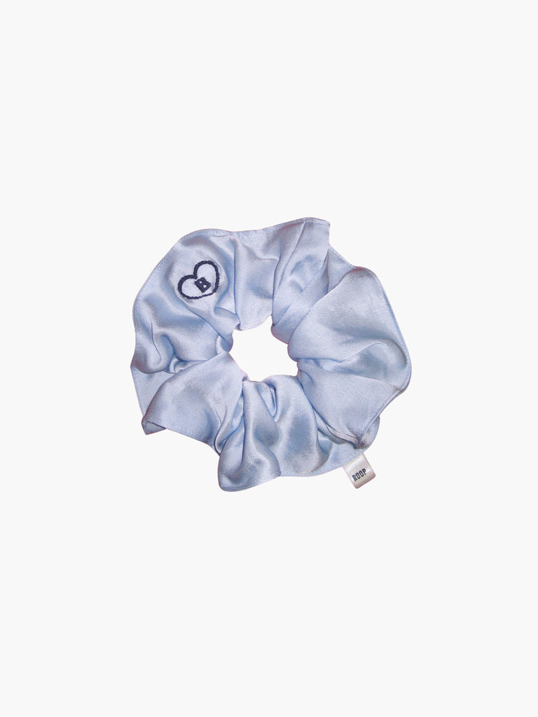 Blue satin scrunchie embroidered with a blue heart with the letter B inside, set on a white background
