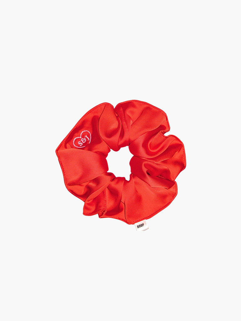 Red satin scrunchie embroidered with a pink heart with the initials S&J inside, set on a white background