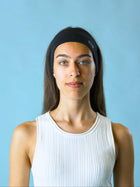 Woman wearing a black stretch headband with ROOP logo on a light blue background