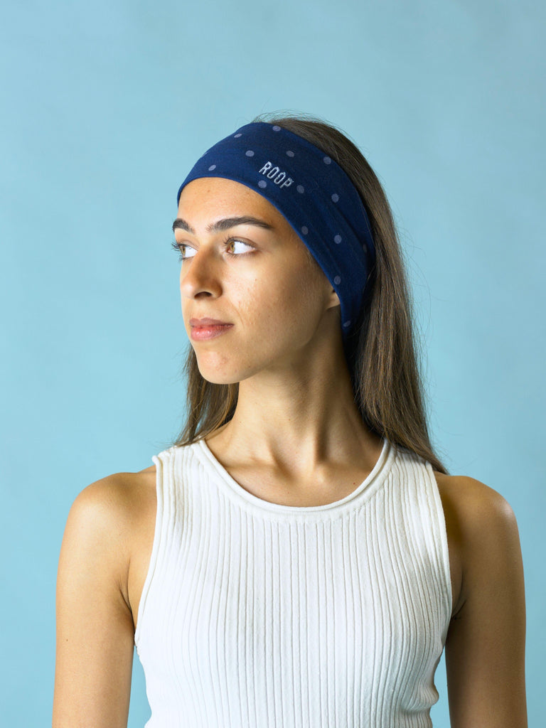 Woman wearing a blue headband with 'ROOP' branding against a light blue background