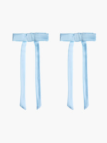Two light blue satin hair bow clips together on a white background