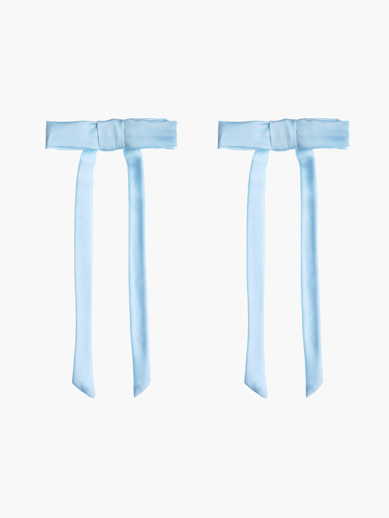 Two light blue satin hair bow clips together on a white background