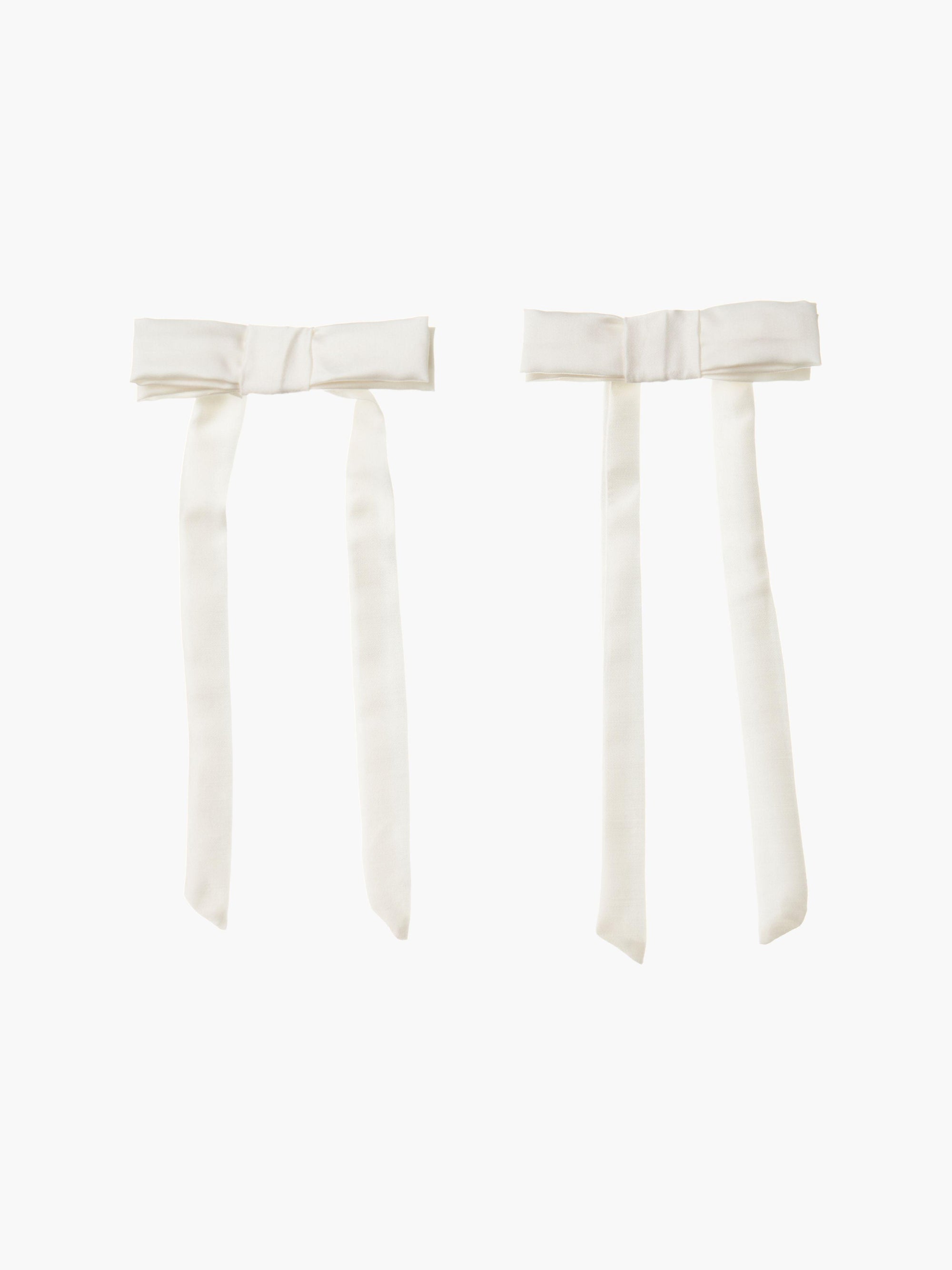 pair of ivory bamboo silk satin hair bow clip hair bow clips on a plain background