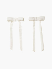 pair of ivory bamboo silk satin hair bow clip hair bow clips on a plain background