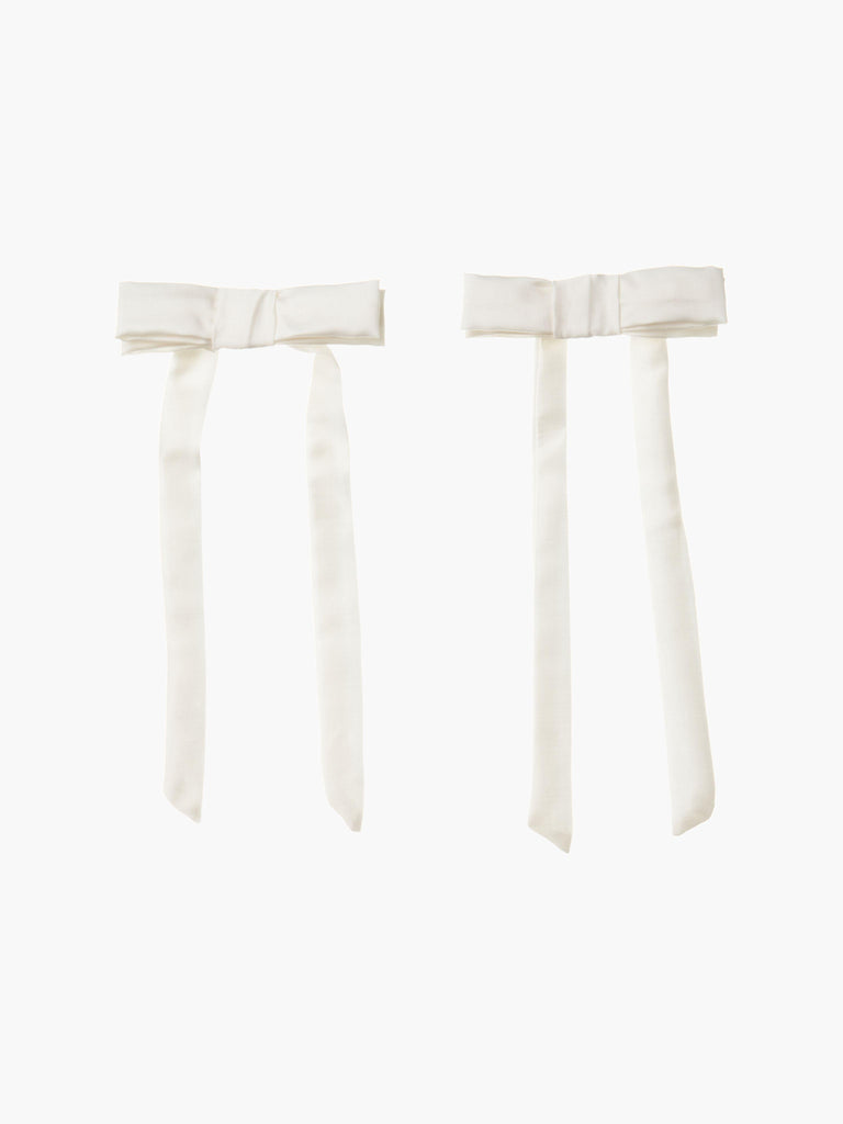 pair of ivory bamboo silk satin hair bow clip hair bow clips on a plain background