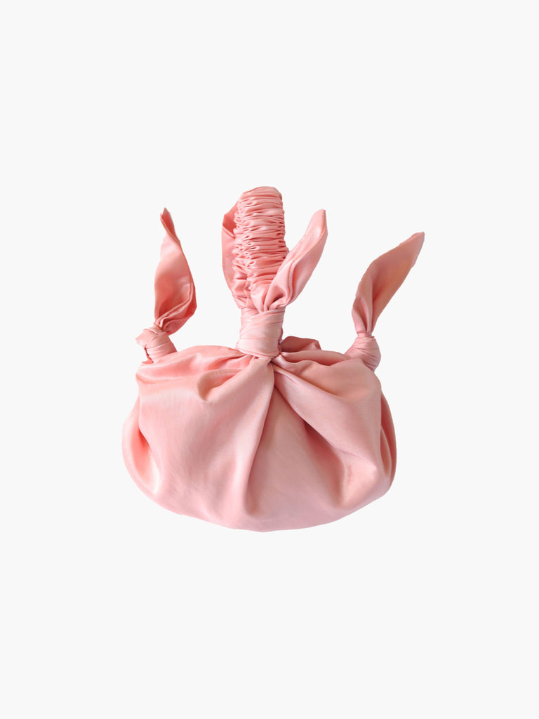pink knotted taffeta handbag on a white background