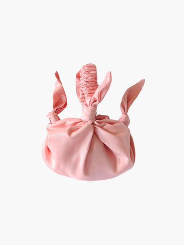 pink knotted taffeta handbag on a white background
