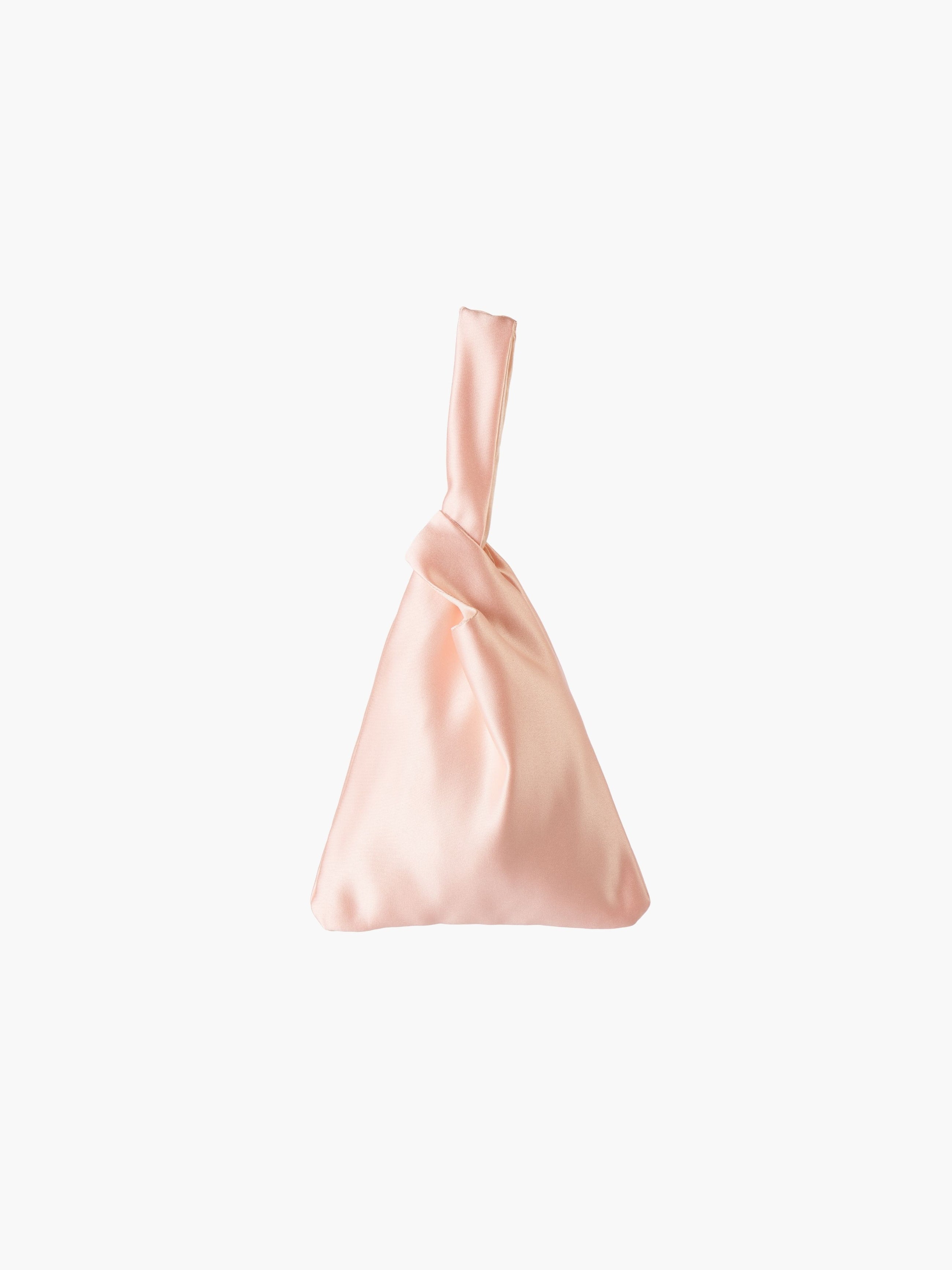 Peach satin knot bag against a plain white background. The elegant bag has a twisted handle and sleek, glossy fabric, exuding a chic, minimalist style.