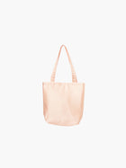 A peach satin tote bag with. It features matching handles, set against a plain white background.