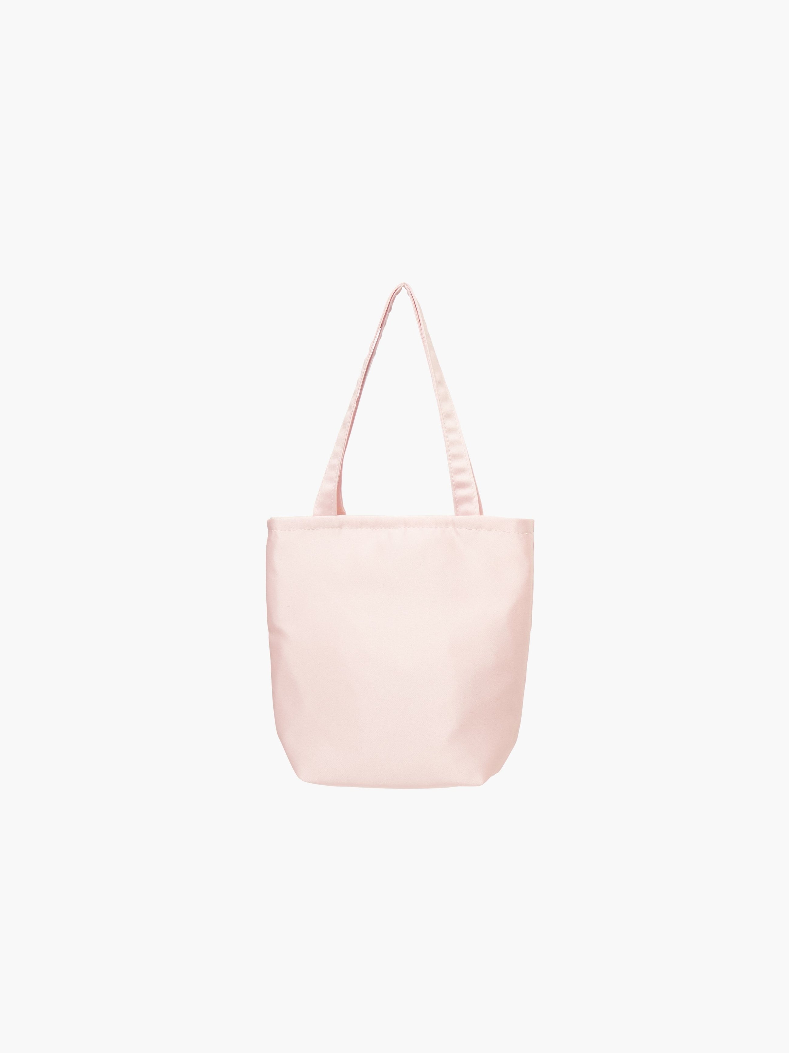 A light pink satin tote bag with. It features matching handles, set against a plain white background.
