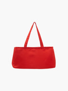 Bright red handbag with a sleek, rectangular design and two handles against a plain white background, conveying a chic and modern style.