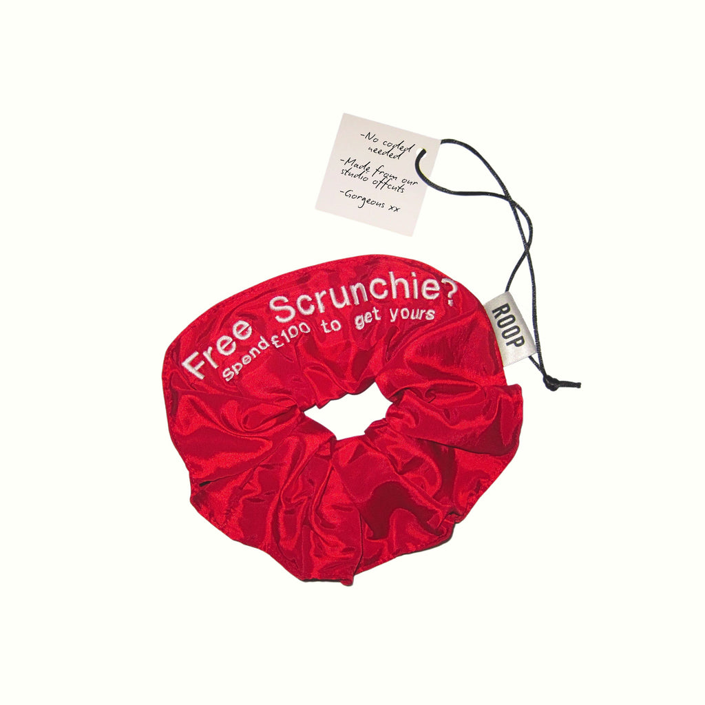 Red scrunchie with promotional text on a white background
