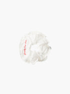 Ivory ruffled scrunchie with red embroidery that reads 'happily ever after' on a white background