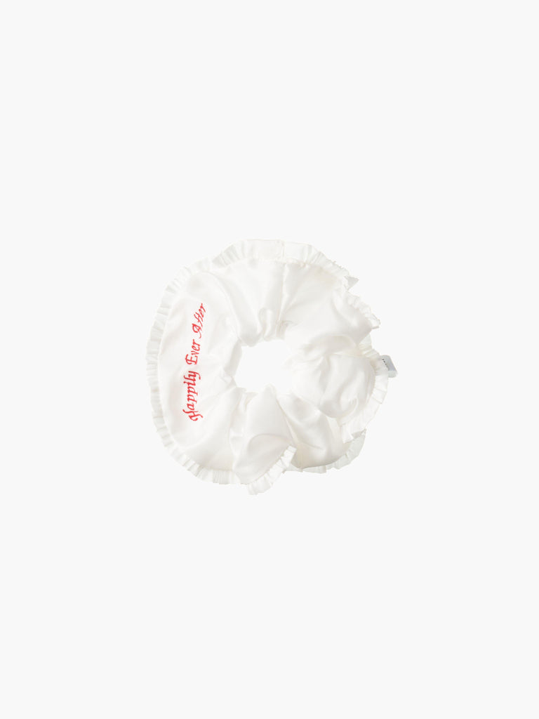 Ivory ruffled scrunchie with red embroidery that reads 'happily ever after' on a white background