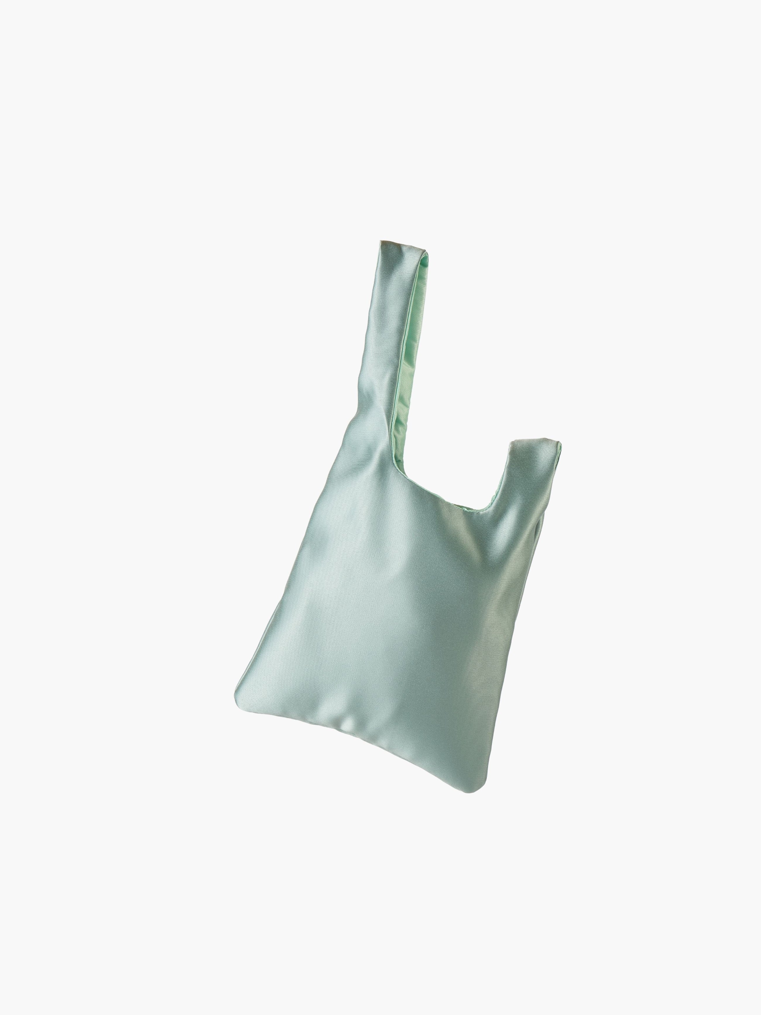 Sea green satin knot bag against a plain white background. The elegant bag has a twisted handle and sleek, glossy fabric, exuding a chic, minimalist style.