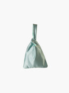 Sea green satin knot bag against a plain white background. The elegant bag has a twisted handle and sleek, glossy fabric, exuding a chic, minimalist style.