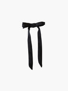 black satin bow hair clip on a white background