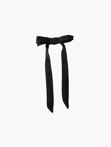 black satin bow hair clip on a white background