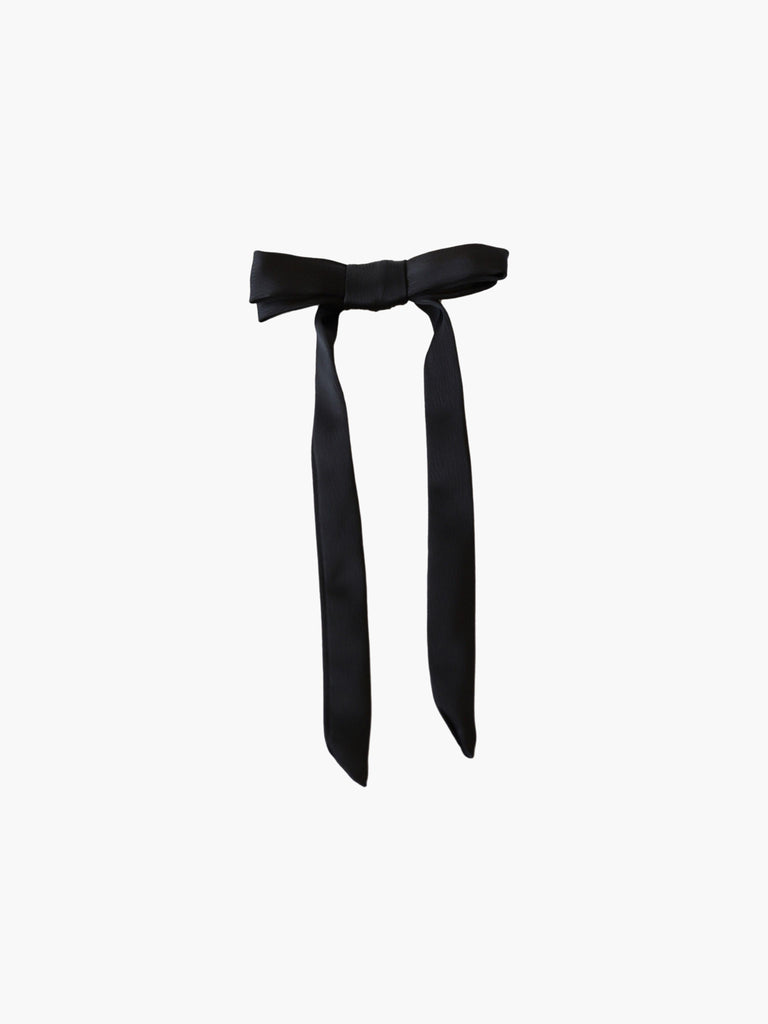 black satin bow hair clip on a white background