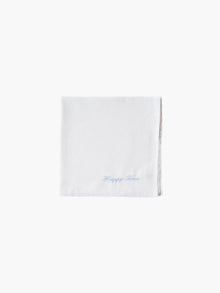 A white cotton embroidered square handkerchief, embroidered with "happy tears" in blue.