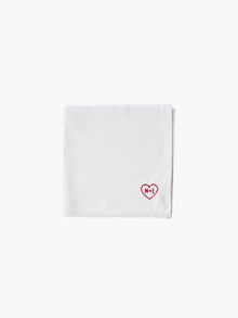 A white cotton embroidered square handkerchief, embroidered with initials inside a red heart, using red thread.