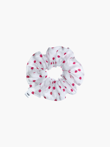 White scrunchie with pink polka dots on a white background