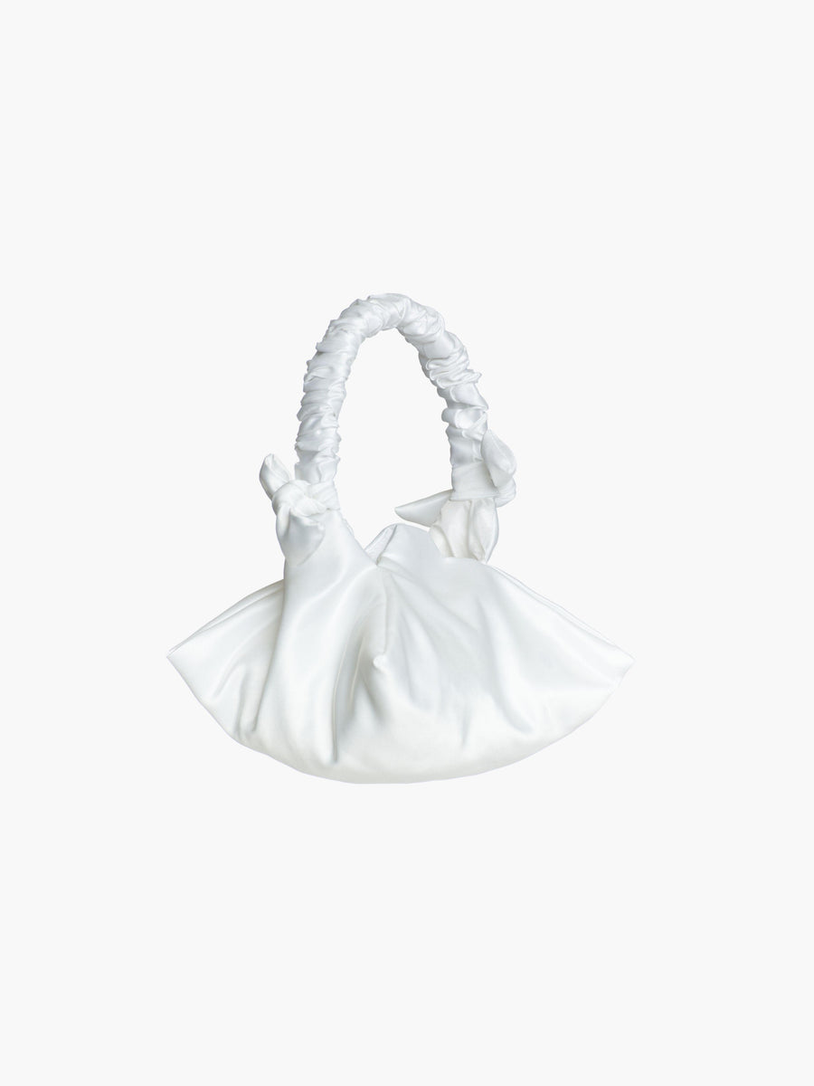 White satin ruched handle handbag with decorative bows, set on a white background