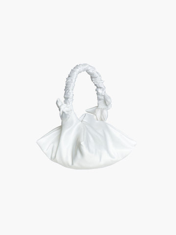 White satin ruched handle handbag with decorative bows, set on a white background