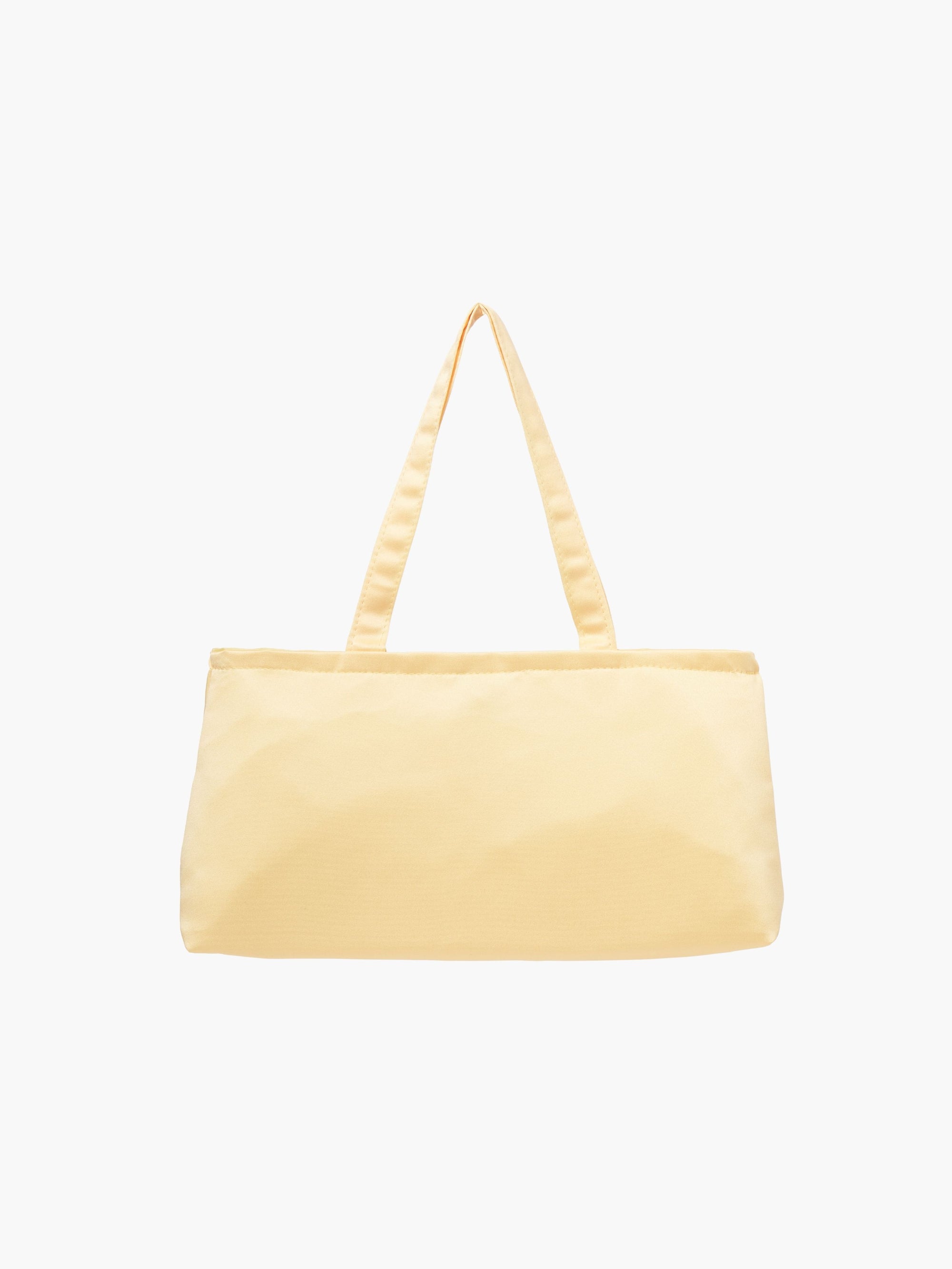 A yellow satin baguette handbag with two handles. 