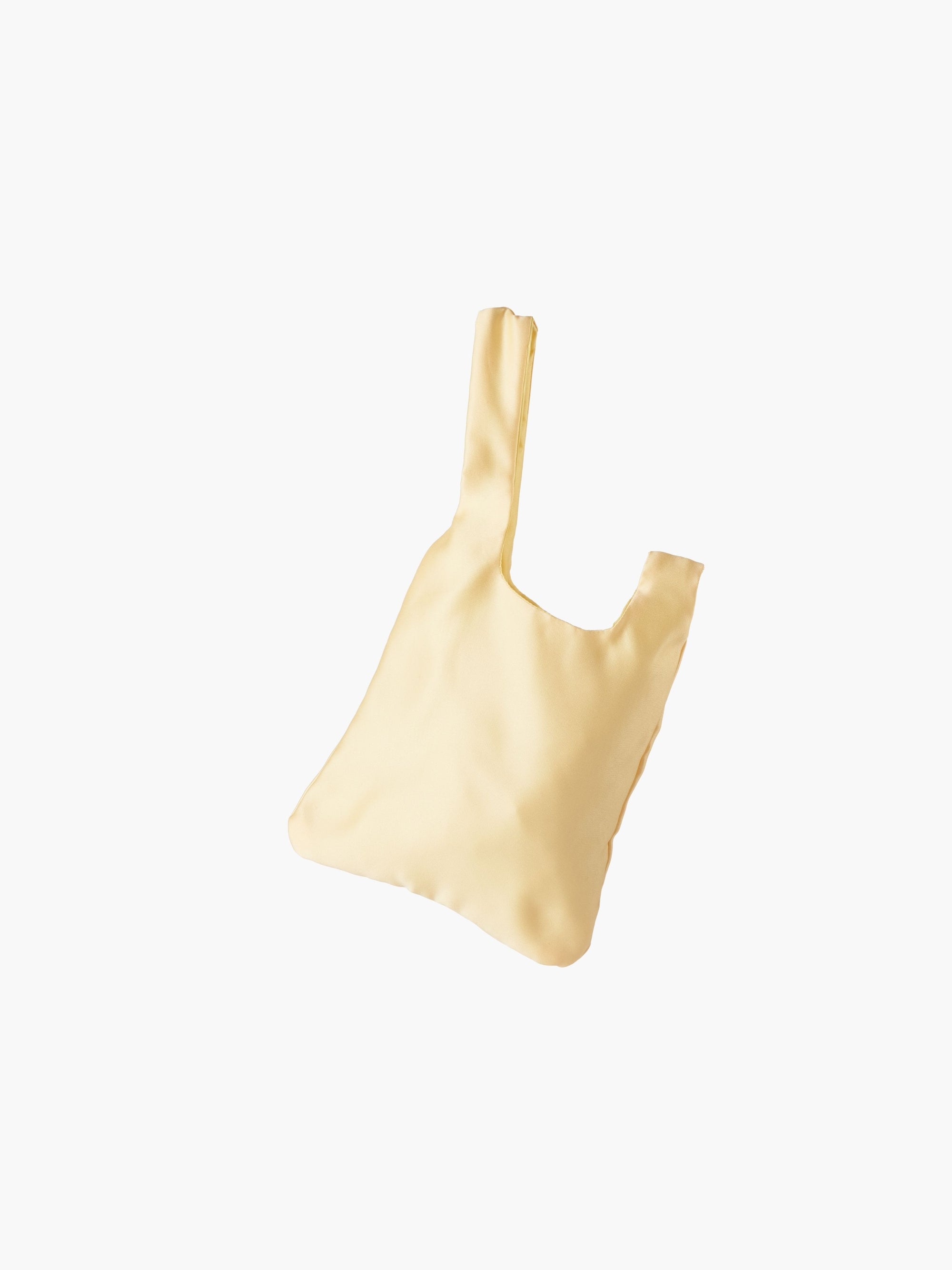 Yellow satin knot bag against a plain white background. The elegant bag has a twisted handle and sleek, glossy fabric, exuding a chic, minimalist style.